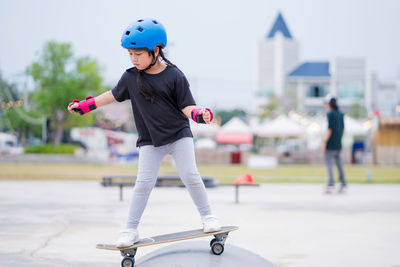 Child or kid girl playing surfskate  in skating rink 