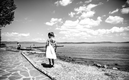 Woman standing on beach against sky