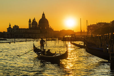 View of boats in canal during sunset