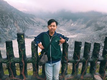 Portrait of young man standing on mountain