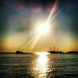 Sailboat sailing in sea at sunset