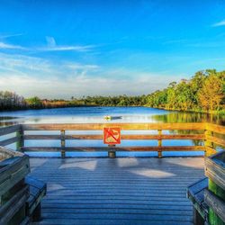 Pier on lake against blue sky