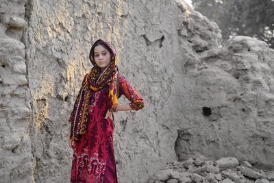 Portrait of woman standing against wall