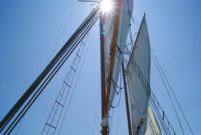 Low angle view of sailboat against clear blue sky