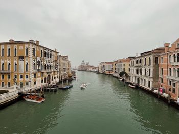 Boats in canal amidst buildings in city