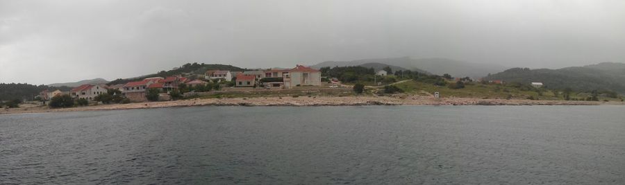 Scenic view of sea with houses in background