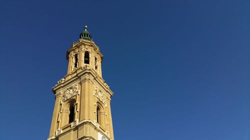 Low angle view of clock tower against blue sky
