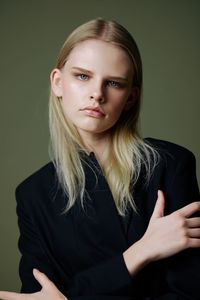 Portrait of young woman against black background