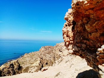 Rock formation on beach against sky