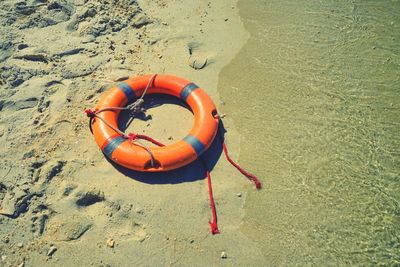 An orange life buoy on the beach