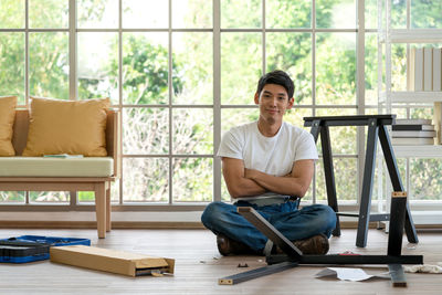 Portrait of young man sitting on floor at home