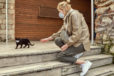 Woman with cat sitting outdoors