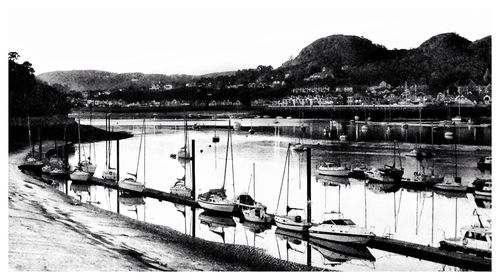 Boats in sea with mountains in background