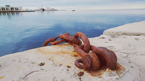 Close-up of chain against calm water