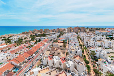 High angle view of townscape by sea against sky