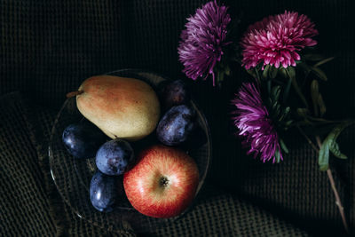 Still life in a dark key fruits and flowers
