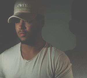 Close-up portrait of young man against black background