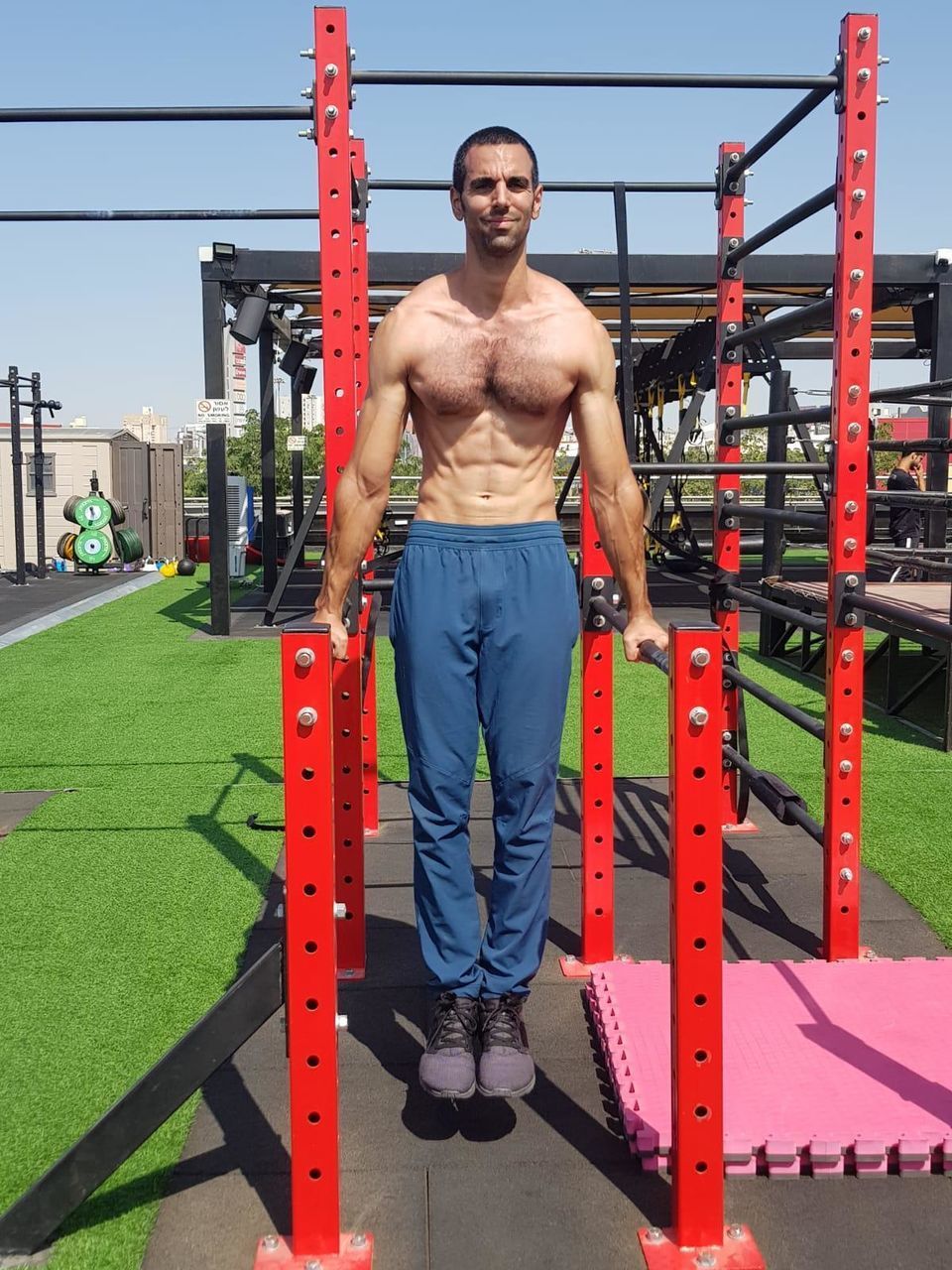 FULL LENGTH PORTRAIT OF YOUNG MAN STANDING AGAINST BUILT STRUCTURES