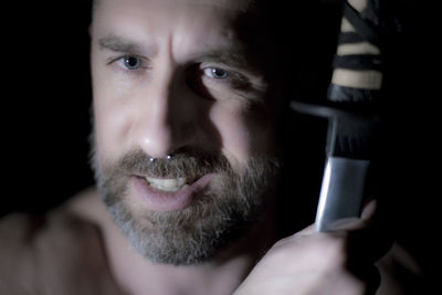 Close-up portrait of man holding camera