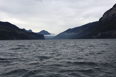 Scenic view of sea and mountains against sky