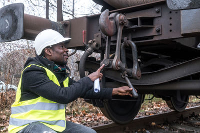 African american mechanic wearing safety equipment checking and inspecting gear train