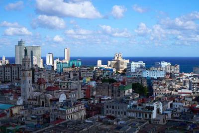 Cityscape by sea against sky