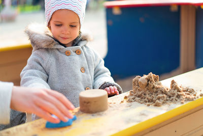 Cute girl playing with sand at playground