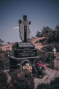 View of cross in cemetery against sky