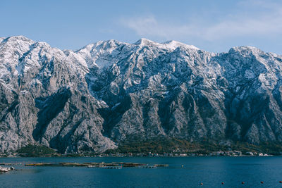 Scenic view of sea and snowcapped mountains against sky