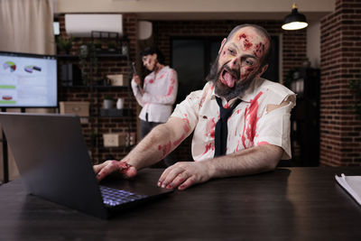 Portrait of young man using laptop on table