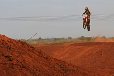 Motocross rider in mid-air against clear sky