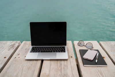 High angle view of laptop on table by swimming pool