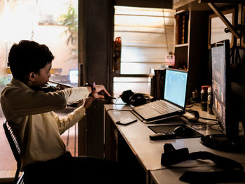  a boy practising his violin infront of a computer at home