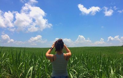 Rear view of woman standing on grassy field