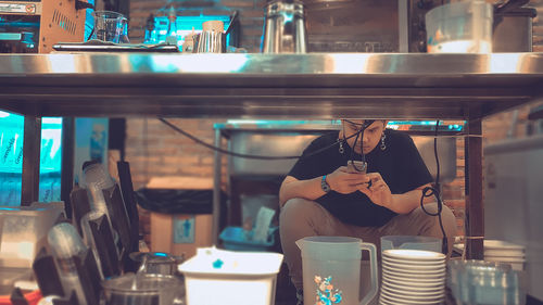 Reflection of woman photographing in restaurant