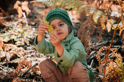 Portrait of cute boy holding autumn leaves