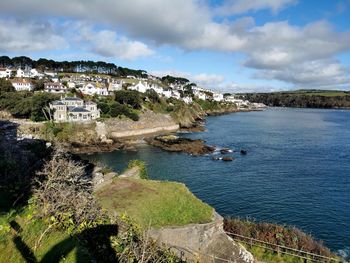 Scenic view of sea by buildings against sky