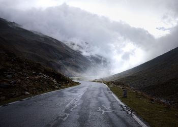 Road amidst mountains against sky