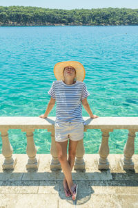 Full length portrait of boy standing in sea