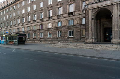 Empty road by buildings in city
