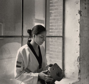 Female taekwondo artist holding helmet