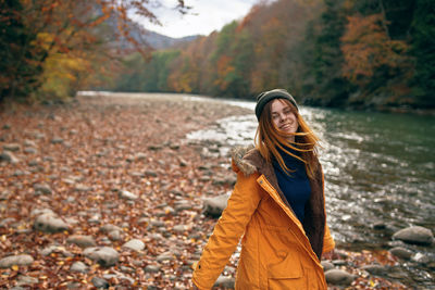 Woman standing by tree during autumn