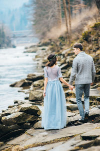 Rear view of couple standing on shore