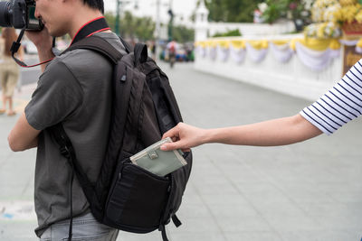 Cropped hand of burglar removing wallet from bag