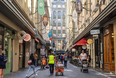 People walking on street amidst buildings in city