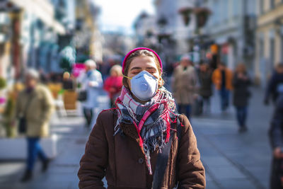 Woman wearing mask while standing in city