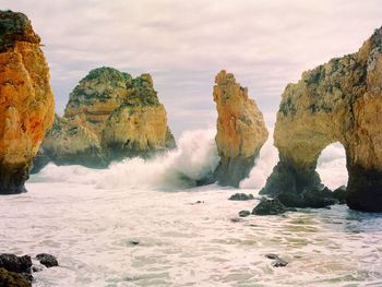 Scenic view of rocks in sea against sky