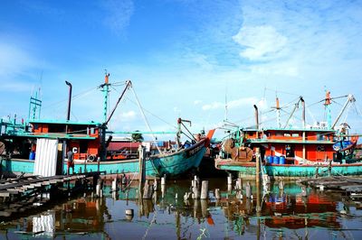 Boats moored at river against sky