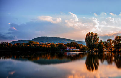 Scenic view of lake by trees against sky