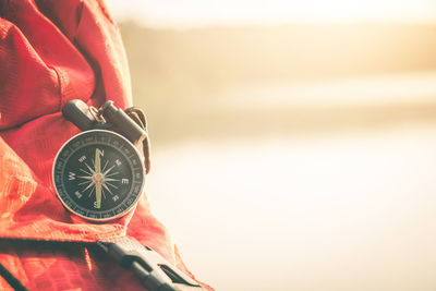 Close-up of hand holding clock against blurred background